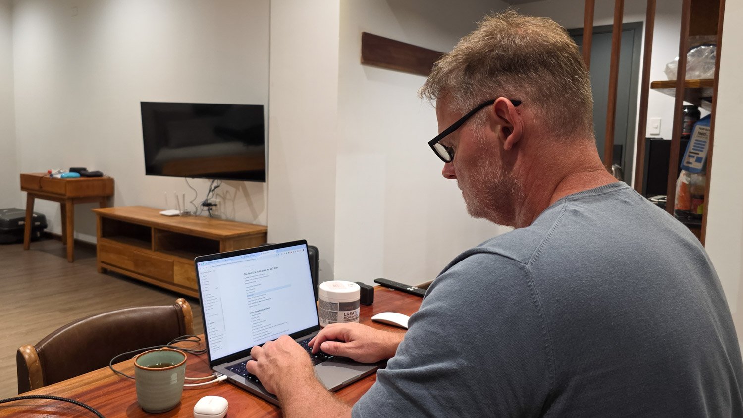 Over-the-shoulder view of Martin Gram writing a field note on his laptop in Da Nang
