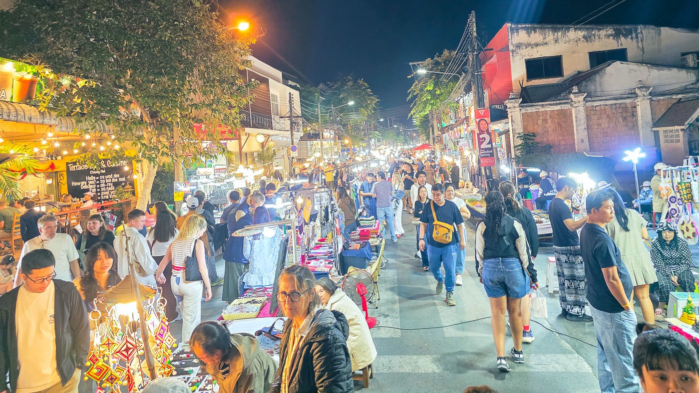 Crowded night market with bright lights and overlapping movement