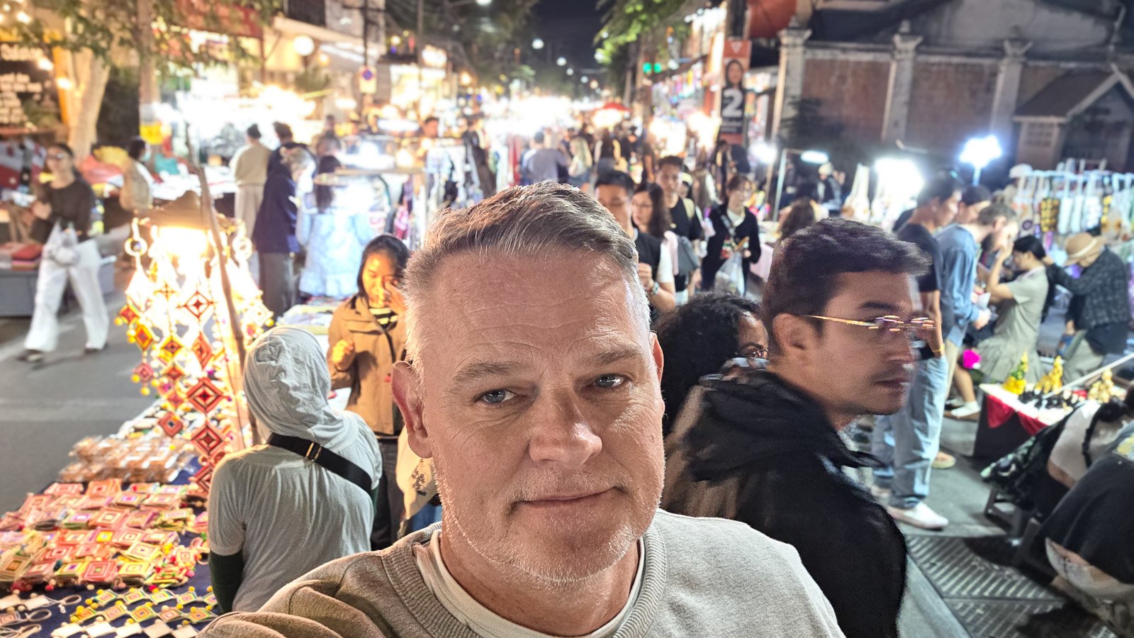 Person sitting still while people move around in a busy environment with blurred motion