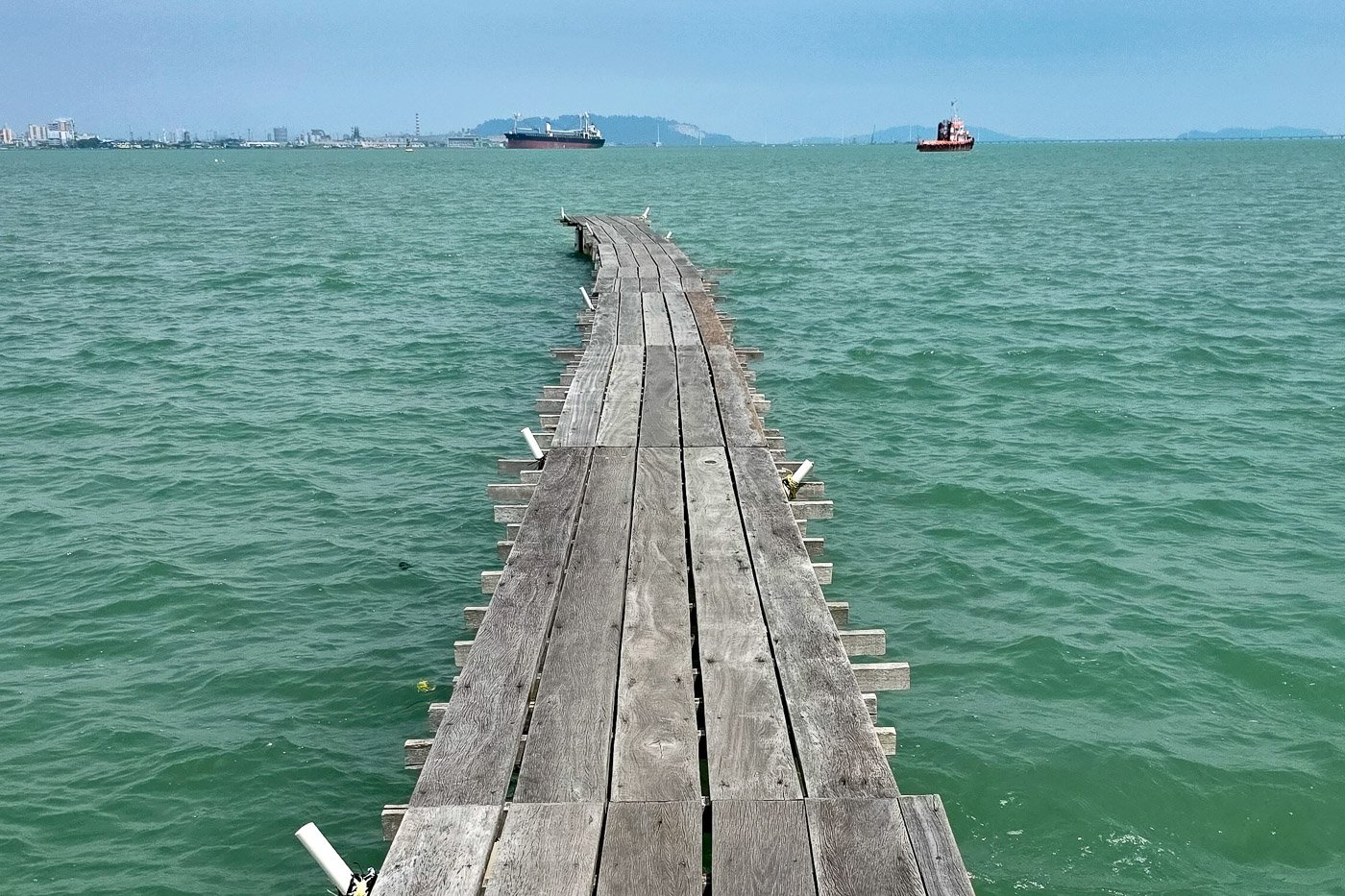 Wooden pier extending into open water at Tan Jetty in George Town, symbolizing direction and alignment.