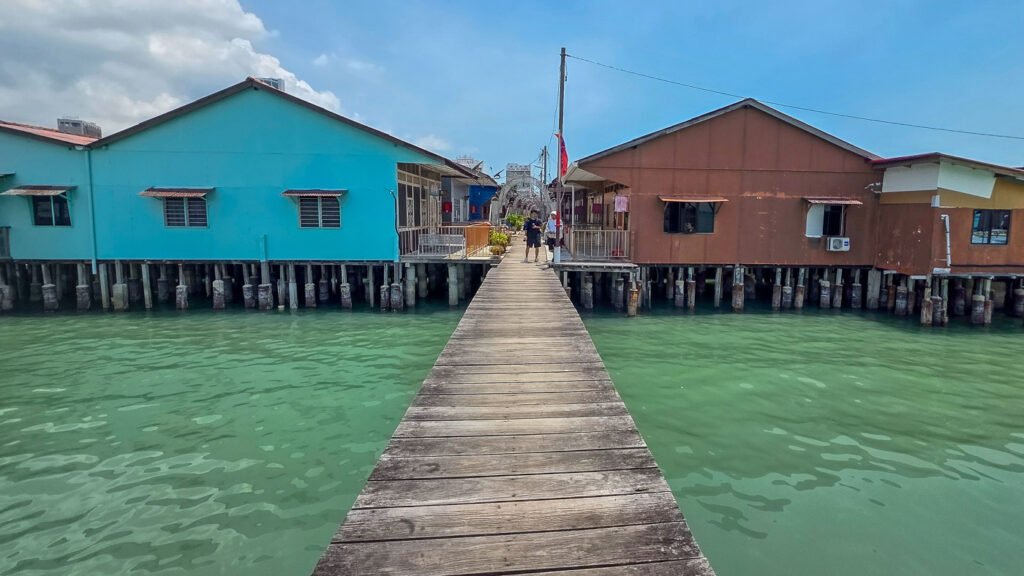 Symmetrical wooden walkway between colorful houses at Chew Jetty in Penang, symbolizing trust, direction, and coherence.