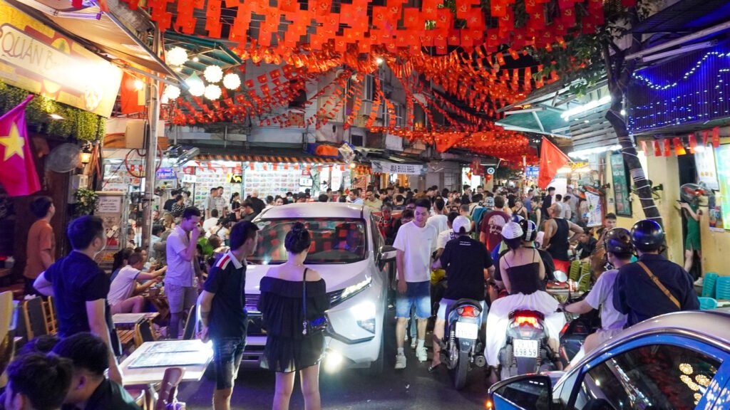 Chaotic street scene in Hanoi Old Town with dense traffic, motorcycles, and pedestrians moving in different directions, representing noise, motion, and environmental drift