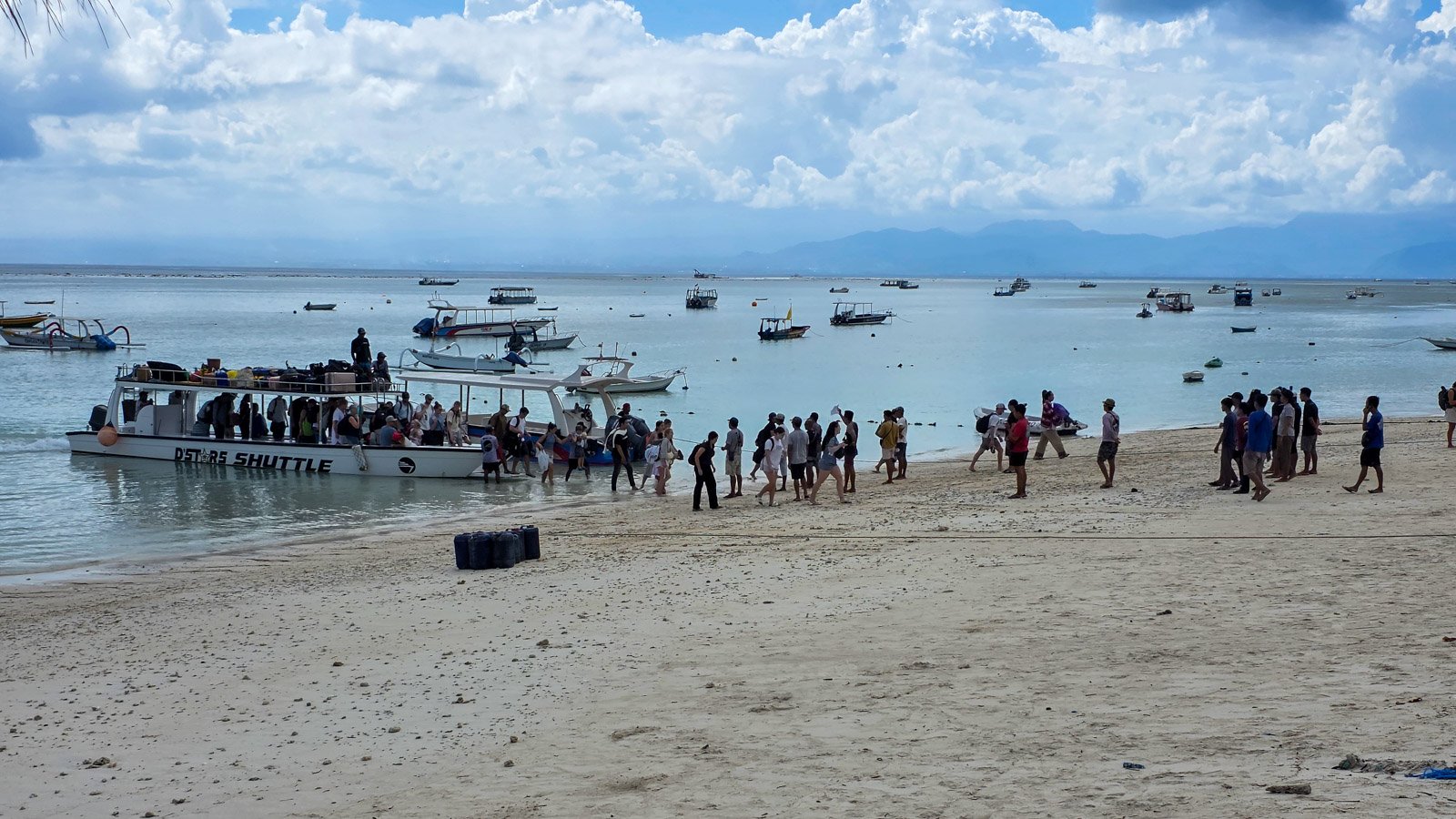Passengers leaving a ferry boat onto the beach in Nusa Lembongan, Bali.
