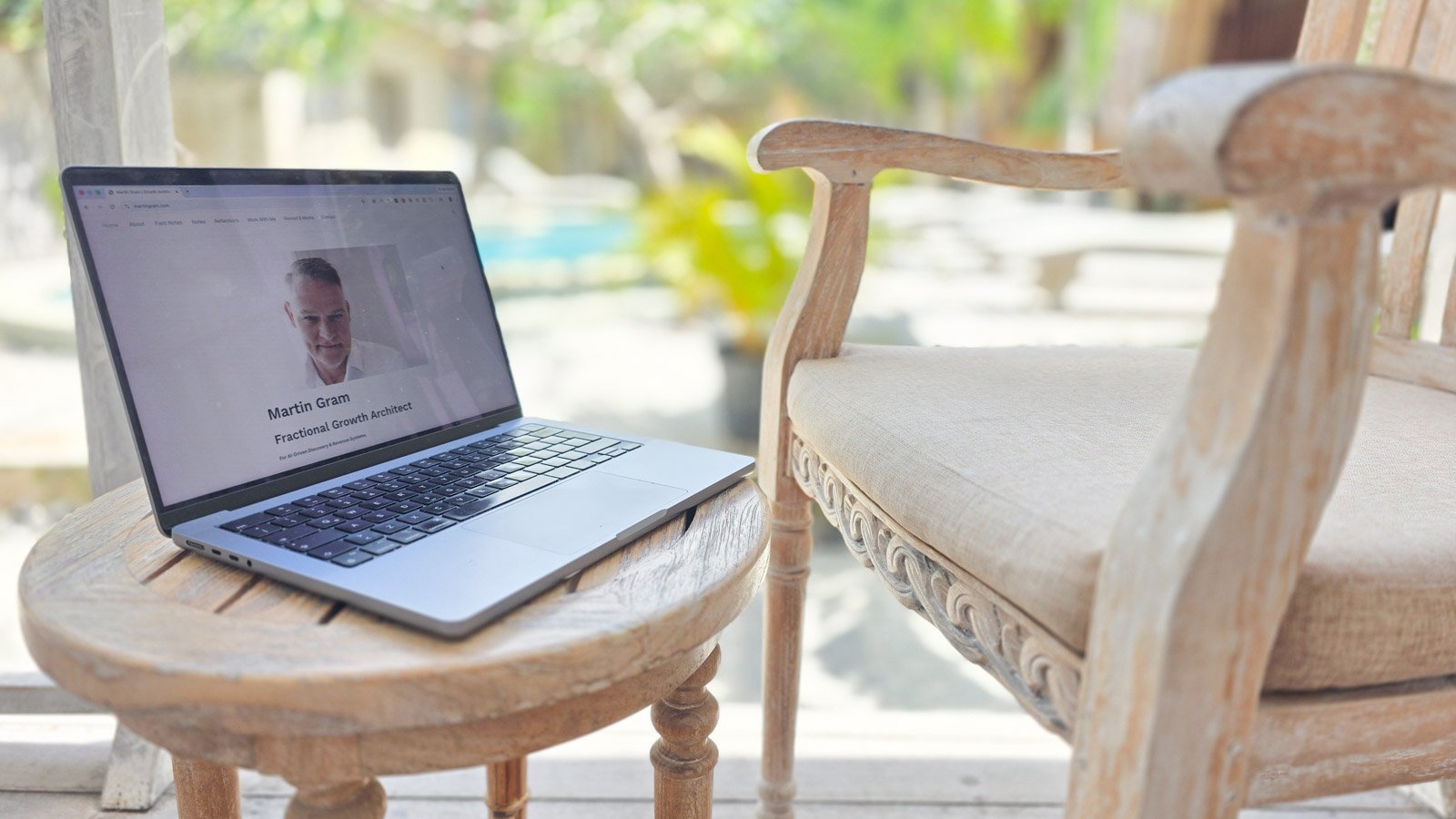 Laptop on a balcony table overlooking a blurred garden on Lembongan Island, Bali