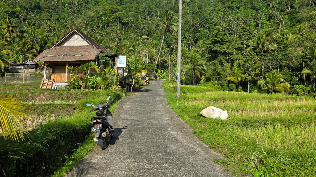 Motorcycle parked on a narrow mountain road near Gembleng Waterfall in Bali